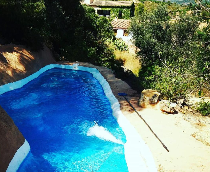 Piscina al aire libre ubicada en plena montaña de la casa rural Aldea Roqueta en Els Ibarsos