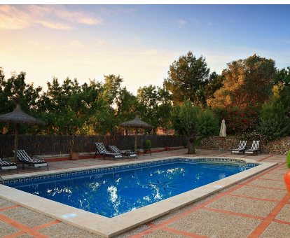 Fantastica piscina al aire libre rodeada de una gran diversidad de arboles Casa Son Malero en Calvia Town