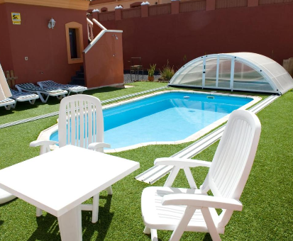 Piscina al intemperie con techo movil de las Villas Anju en Corralejo