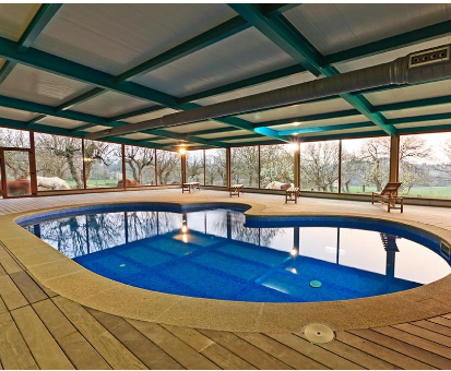 Hermosa piscina interior ovalada con vista al campo de la Casa Cazoleiro en Meira 