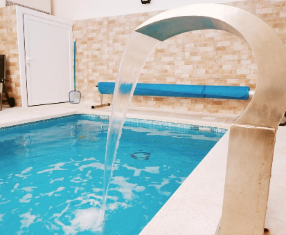 Piscina interior rectangular con vista hacia el jardín de las Casas de Valois en Hita