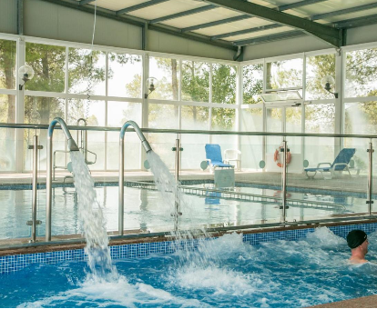 Piscina interior muy amplia con grandes fuentes y chorros de agua. Cabañas Valle del Cabriel, Villatoya