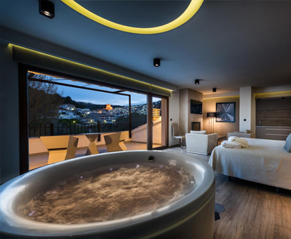 Foto de la habitación con jacuzzi redondo cerca de la cama del resort Finca Los Olivos