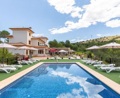 Hotel rural con amplia zona exterior y piscina con vistas a la naturaleza.