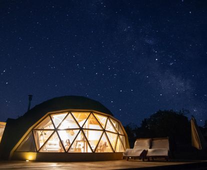 Domo con zona exterior privada e iluminación nocturna en una bella noche estrellada.