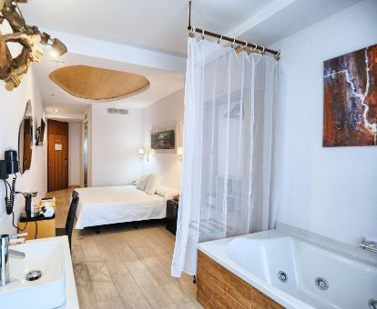 Hermosa suite junior con bañera de hidromasaje privada cerca de la cama en este moderno hotel para parejas.