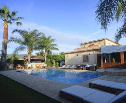 Agradable zona exterior con piscina al aire libre rodeada de tumbonas de este coqueto hotel ideal para parejas.
