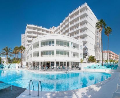 Moderno hotel solo para adultos con piscina al aire libre y solarium con tumbonas.