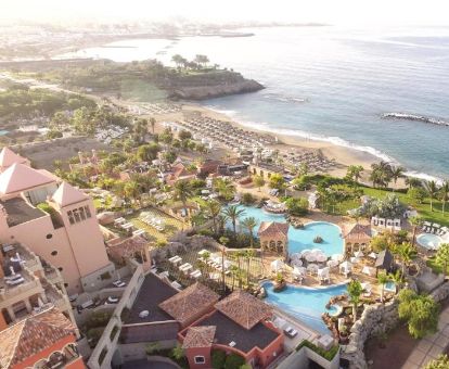 Vista aérea de las zonas exteriores con piscinas y mobiliario de este hotel en primera línea de playa.