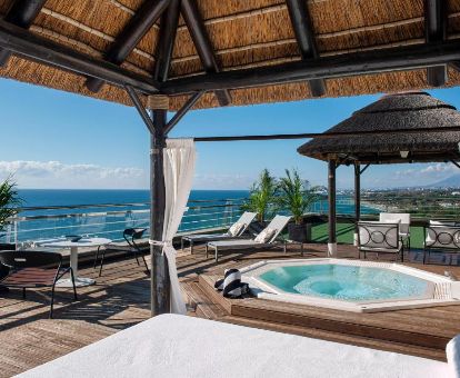 Terraza con vistas al mar, mobiliario y jacuzzi privado de la Suite Ático Möet & Chandon de este hotel romántico.