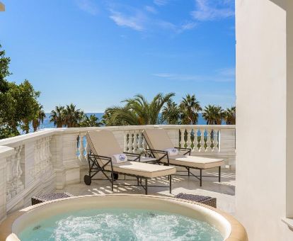 Terraza con tumbonas, jacuzzi privado y vistas al mar de la suite real de este lujoso hotel.