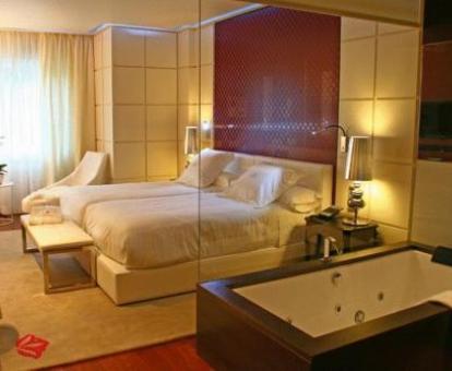 Foto de la Habitación Doble Superior con bañera de hidromasajes junto a la cama.