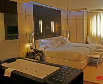 Fabulosa habitación con bañera de hidromasaje privada junto a la cama en este romántico hotel.
