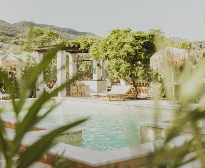 Hermosa zona exterior con piscina rodeada de vegetación de este alojamiento rural solo para adultos.