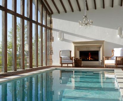 Agradable piscina interior con hermosas vistas y zona de relajación con chimenea de este elegante hotel.
