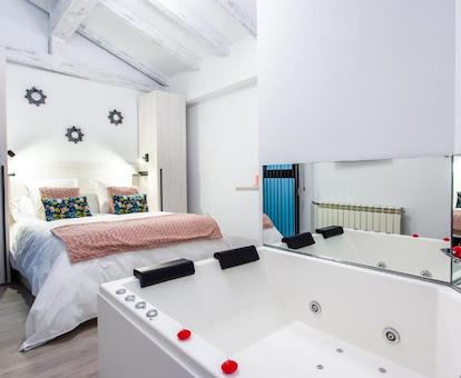 Bañera de hidromasaje privada junto a la cama de uno de los estudios del alojamiento.