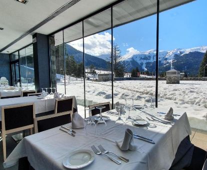 Comedor interior con amplios ventanales y fabulosas vistas al paisaje nevado que rodea el hotel.