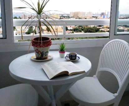 Foto del balcón con comedor exterior y vistas a la ciudad y al mar de uno de los apartamentos de este establecimiento.