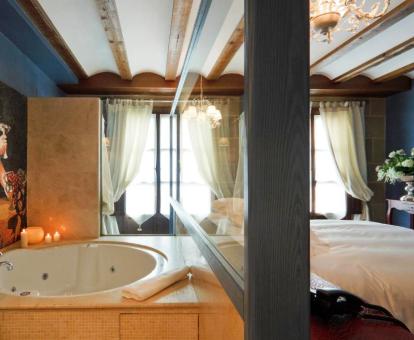 Foto de la Habitación Doble con bañera de hidromasaje cerca de la cama.