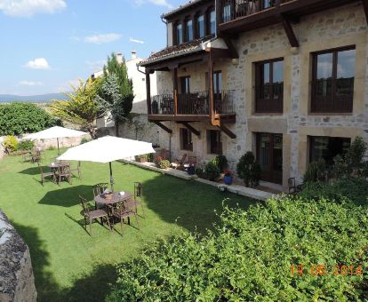 Edificio de este acogedor hotel rural con terraza ajardinada y mobiliario al aire libre.