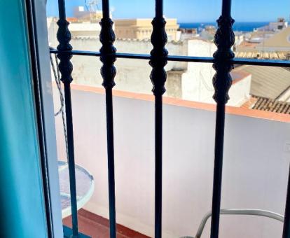Foto de la ventana con vistas al mar y a la ciudad de una de las habitaciones de este hostal.