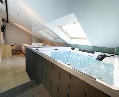 Preciosa suite deluxe con bañera de hidromasaje privada cerca de la cama.