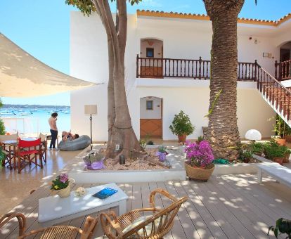 Terraza con mobiliario de uso compartido de este acogedor hostal a pie de playa.