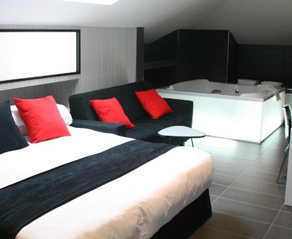 Foto la suite del Hotel Indiana en Pinto donde vemos la cama doble con el jacuzzi que se encuentra al fondo de la habitación y cerca de la cama.