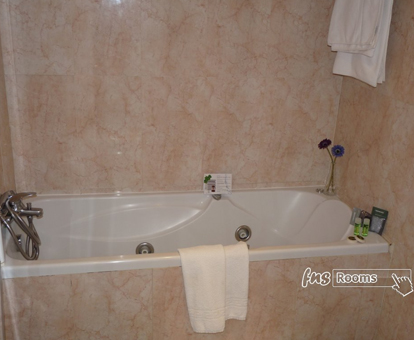 Foto de la bañera con hidromasaje y azulejos de mármol del Hotel Jardín de Aranjuez