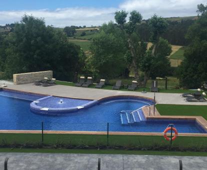 Foto de la piscina con solarium y amplios jardines del alojamiento.