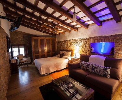 Foto de la Suite Junior donde vemos el estilo rústico de la habitación y los techos de madera de este hotel solo para adultos.