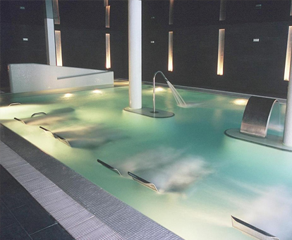 Foto del spa con chorros de agua e iluminación ambiental que se encuentra en el Hotel Real Balneario Carlos III