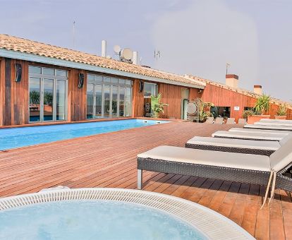 Agradable terraza solarium con piscina y jacuzzi exterior de este romántico hotel para parejas.