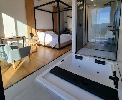 Hermosa habitación con bañera de hidromasaje privada cerca de la cama en este moderno hotel ideal para parejas.