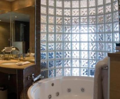 Bañera de hidromasaje privada circular en la suite del hotel.