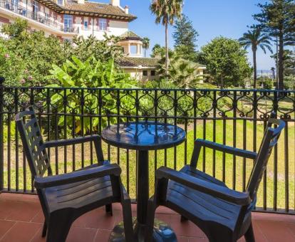 Foto de la terraza amueblada con vistas a los jardines del hotel con el mar de fondo de una de las habitaciones del hotel.