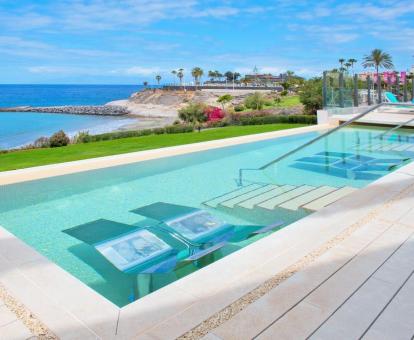 Foto de la piscina con camas de agua y vistas al mar.