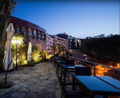 Edificio de este hotel con terraza y comedor exterior con vistas.