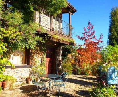 Alojamiento rural rodeado de jardines con mobiliario exterior.