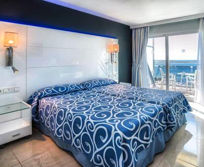 Foto de una de las alegres habitaciones del hotel con terraza privada y vistas al mar.