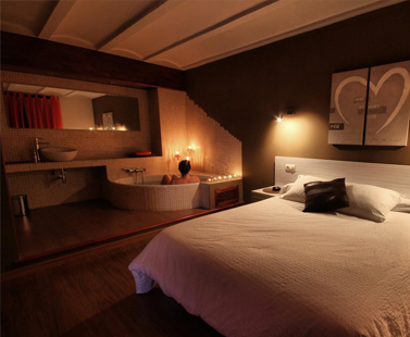 Foto de la habitaciÃ³n con baÃ±era de hidromasaje al lado de la cama, en La Casa del Mercat en CastellÃ³n