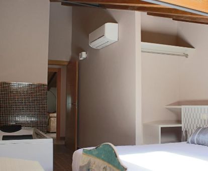 Dormitorio con bañera de hidromasaje privada cerca de la cama del apartamento deluxe.