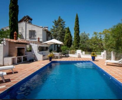 Acogedor hotel con piscina exterior y zona de barbacoa en un tranquilo entorno para descansar.