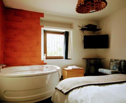 Foto de la bañera de hidromasajes cerca de la cama de uno de los dormitorios de la casa.