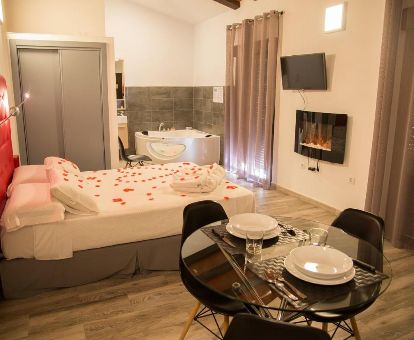 Dormitorio con jacuzzi privado junto a la cama de uno de los estudios de este alojamiento romántico.