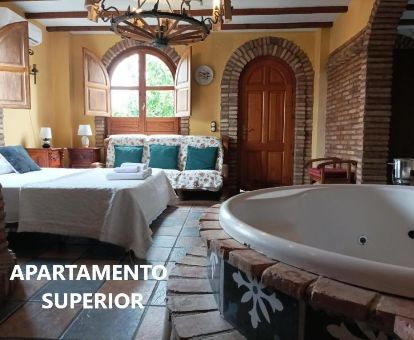 Dormitorio del apartamento superior con jacuzzi junto a la cama de este establecimiento rural.