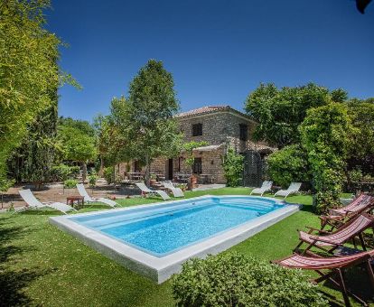 Edificio de este hotel rural rodeado de vegetación con piscina al aire libre.