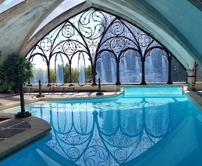 Preciosa piscina interior con elementos de estilo gótico de este precioso hotel.