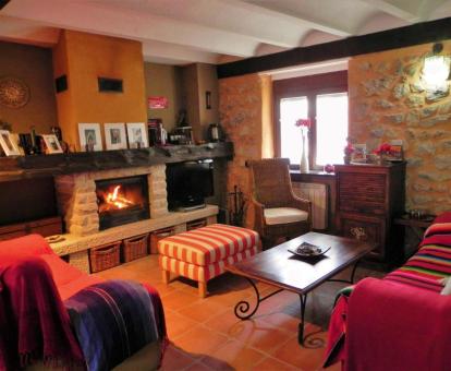 Foto de la sala de estar con televisión y chimenea de esta bonita casa rústica.