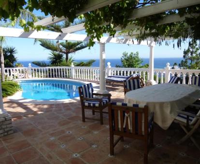 Foto de la terraza comunitaria con piscina y vistas al mar de este establecimiento.